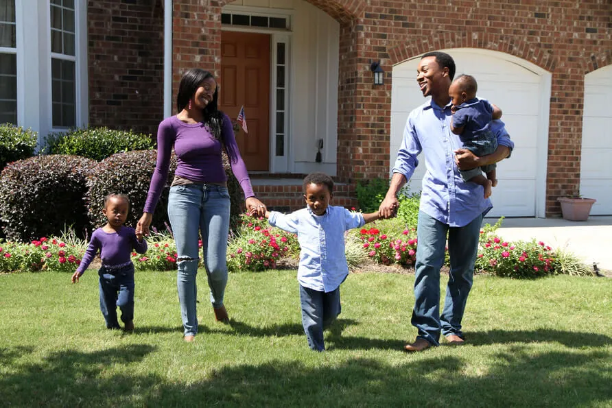 Picture of family outside home they purchased with Chris James as their agent